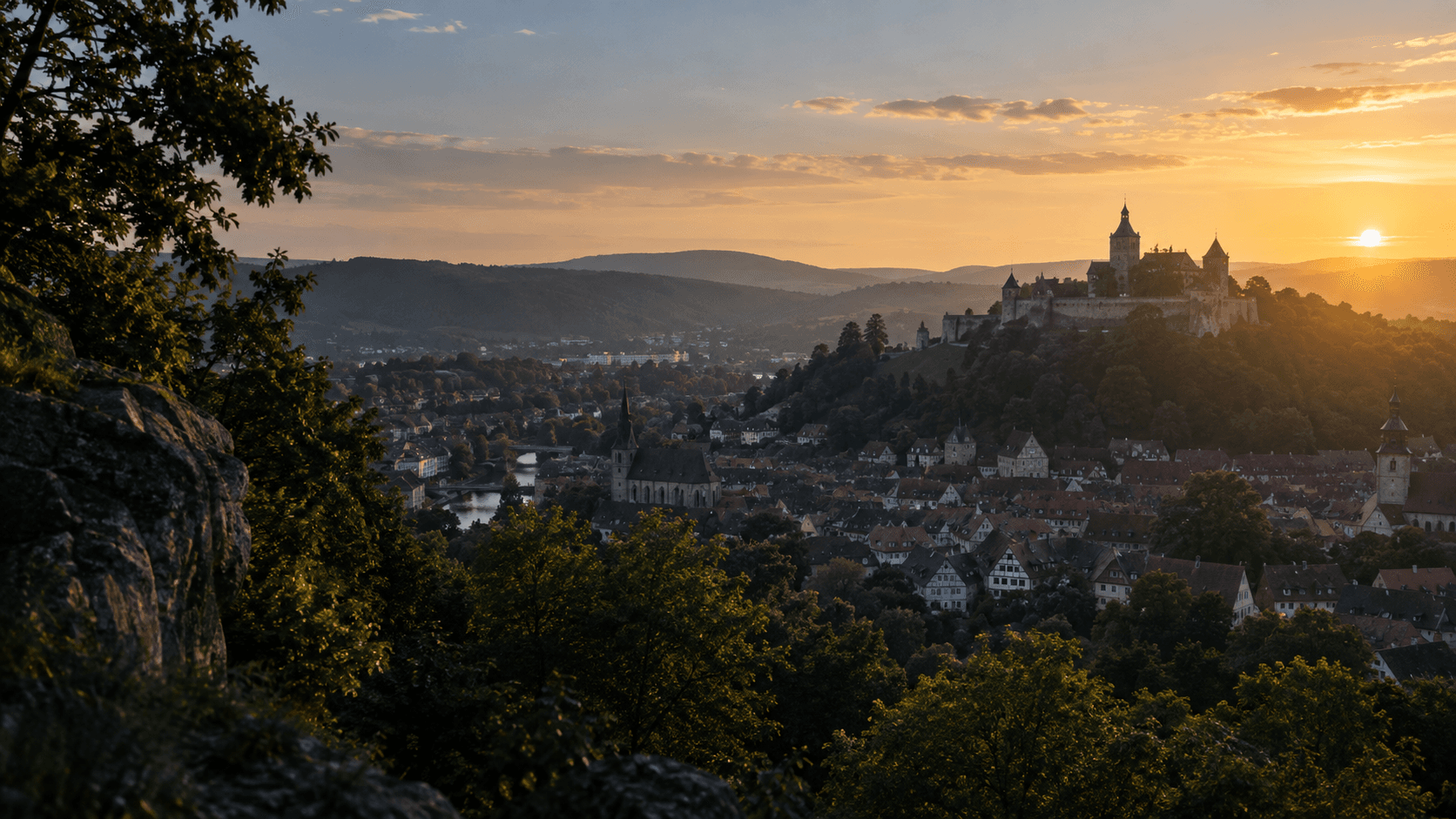 Illustration einer fränkisch anmutenden Stadt mit Burg im Abendlicht